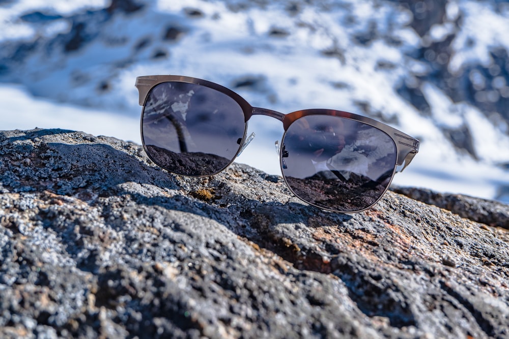 brown framed sunglasses on rocky ground