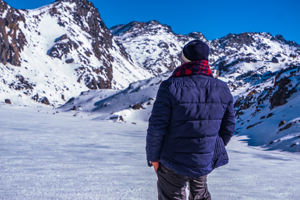 man in black jacket and black pants standing on snow covered ground during daytime