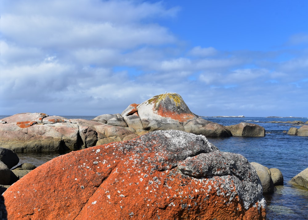 brown rock formation near body of water during daytime