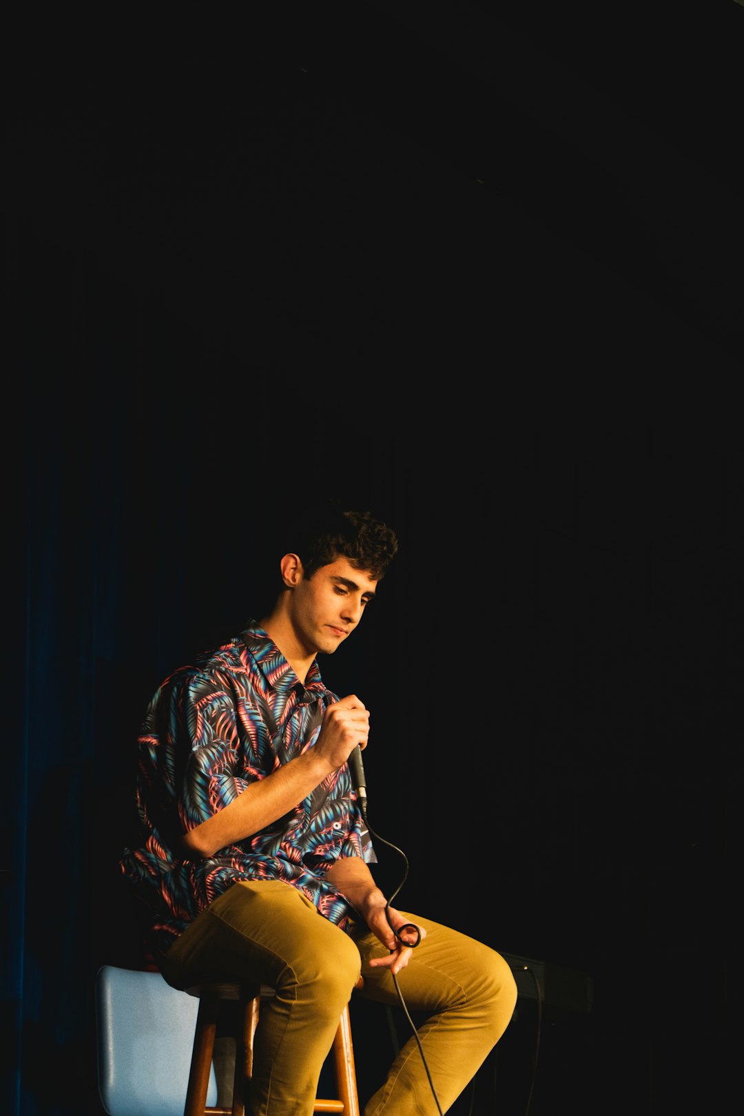 man in blue and white floral button up shirt singing