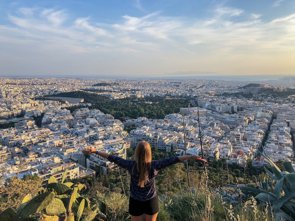 woman in black long sleeve shirt standing on top of the mountain during daytime