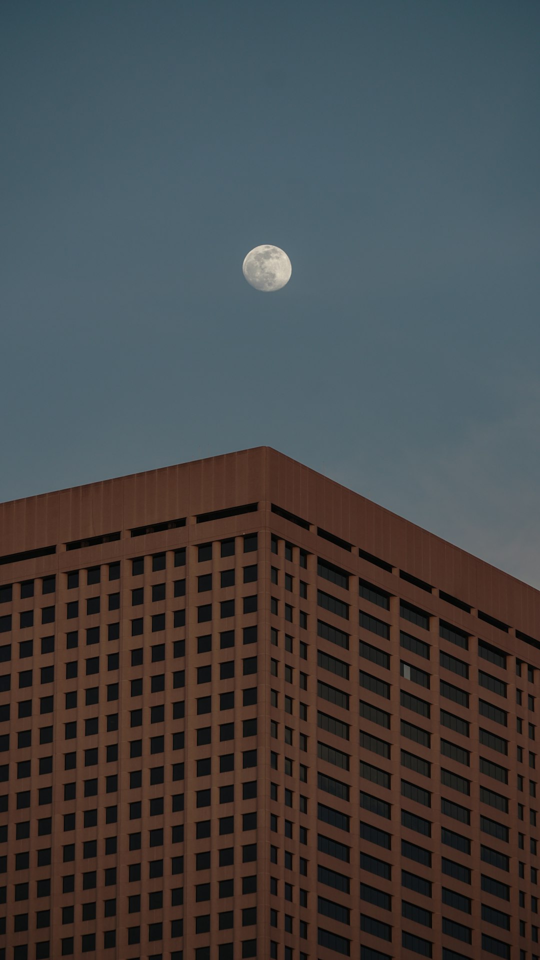 full moon over brown building