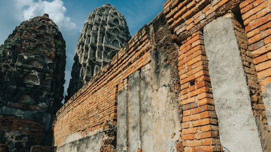 brown brick wall under blue sky during daytime in Sukhothai Historical Park Thailand