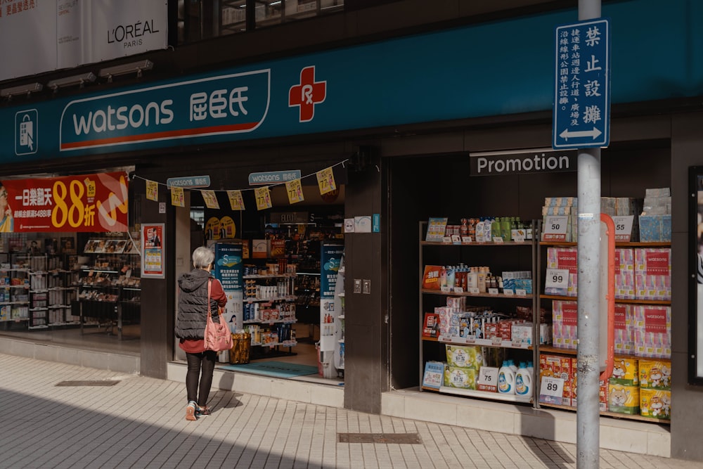 woman in red and white floral dress standing near store