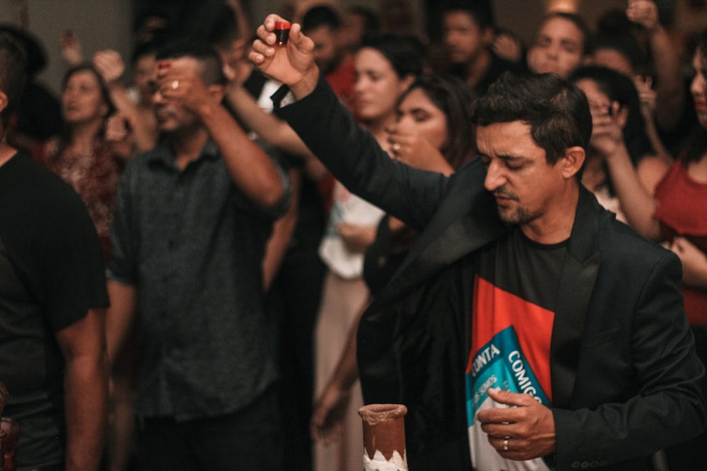 man in black jacket holding glass of beer