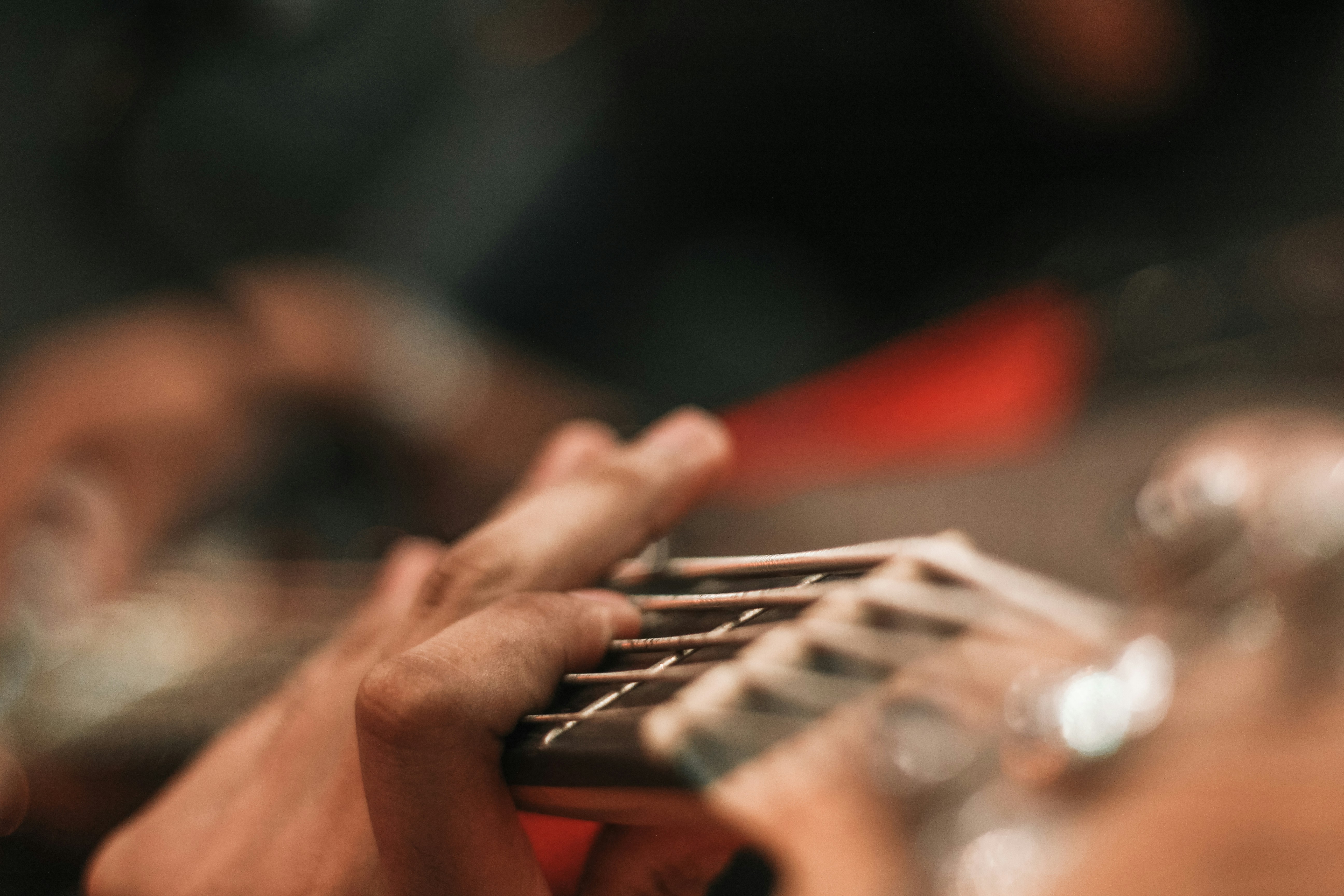 person playing red and black electric guitar
