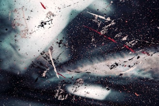 An abstract piece with bold splashes of red and gold on a dark background.