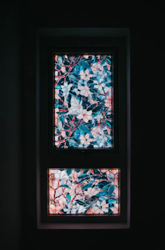 Close-up of a colorful stained glass window featuring floral patterns in a historic building