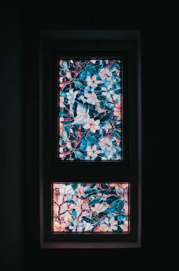 Close-up of a vibrant stained glass panel with intricate floral patterns glowing in natural light.