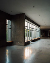 Bright hospital corridor with sunlight streaming through large windows.