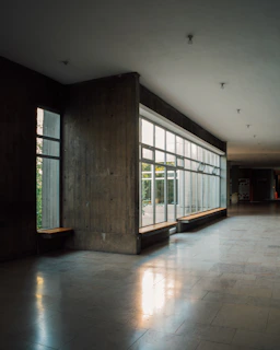 Bright hospital corridor with sunlight streaming through large windows.