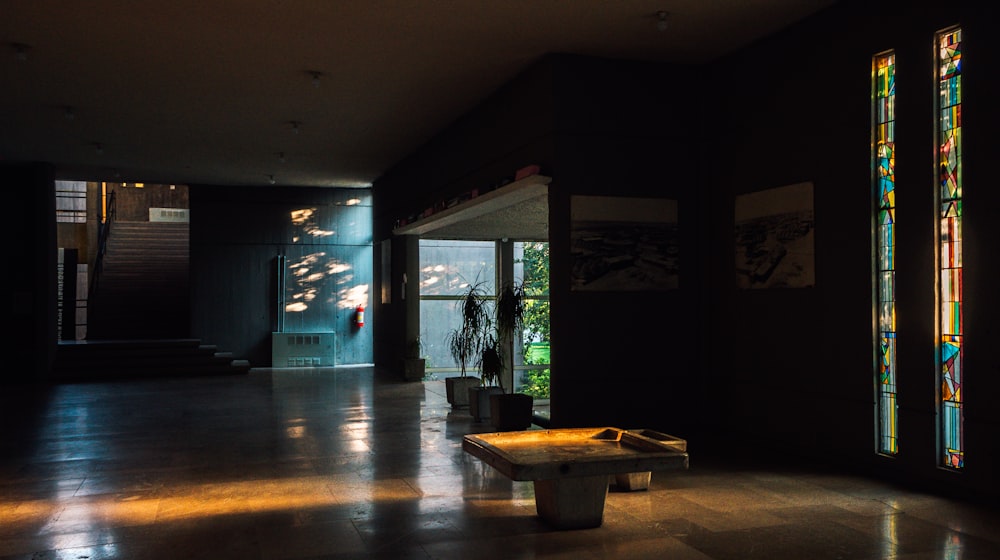 brown wooden table near glass window