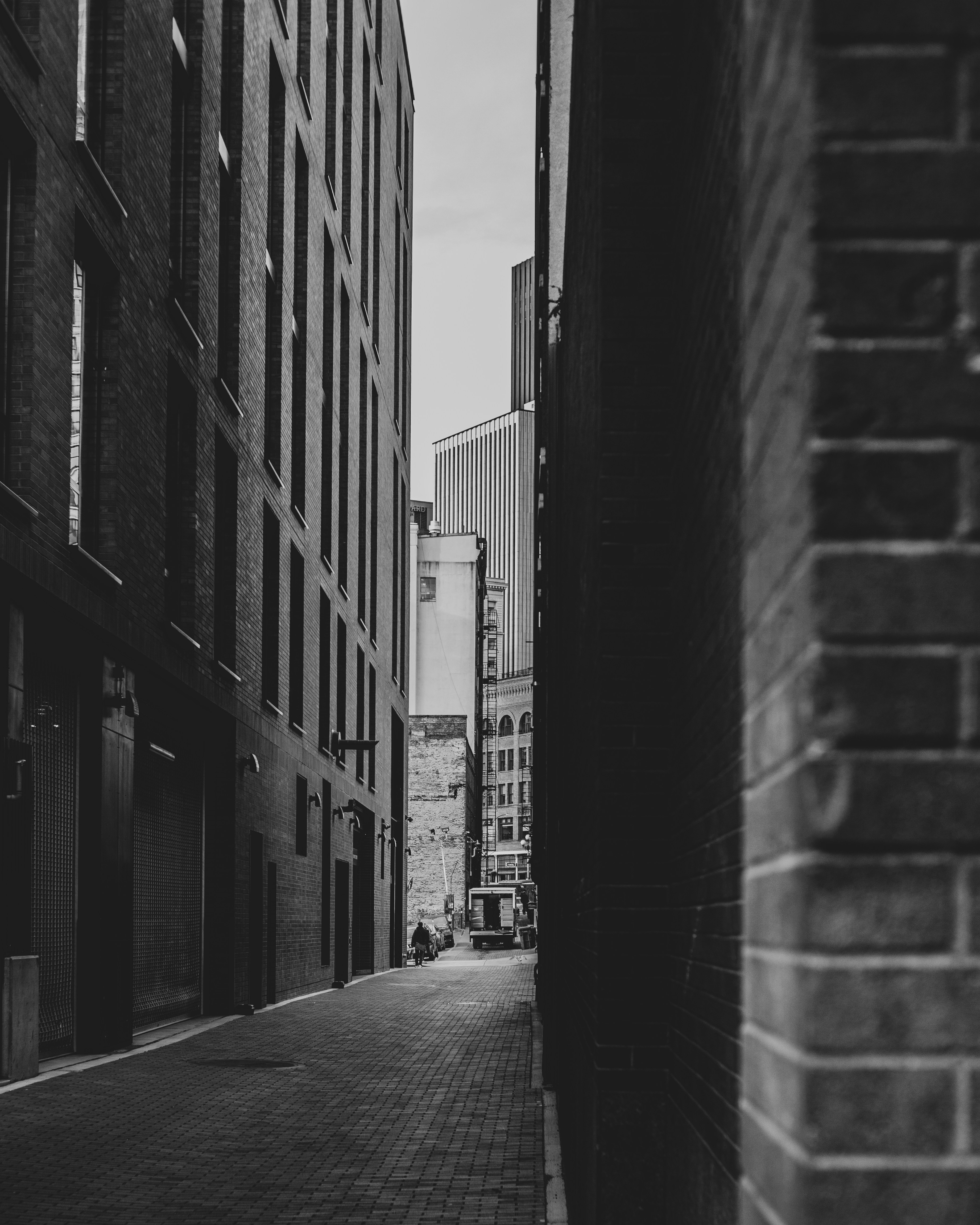 grayscale photo of empty street between buildings
