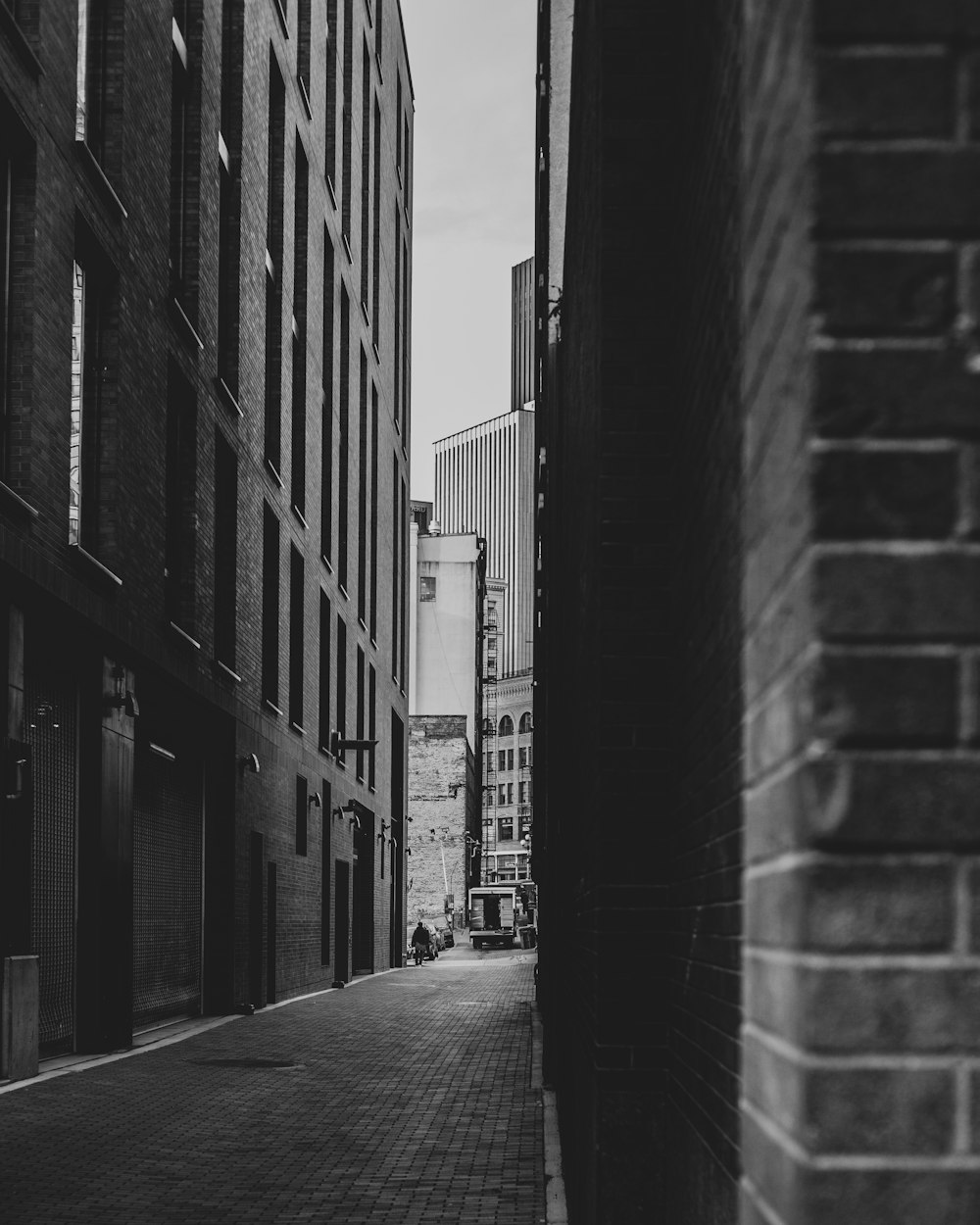 建物と建物の間の空っぽの通りのグレースケール写真
