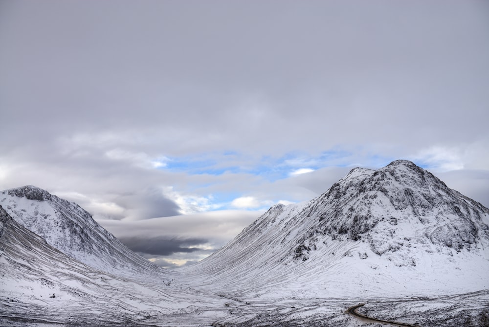 snow covered mountain under cloudy sky during daytime