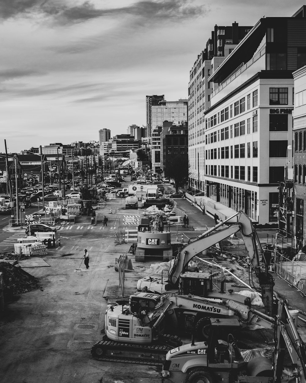 grayscale photo of cars on road near buildings