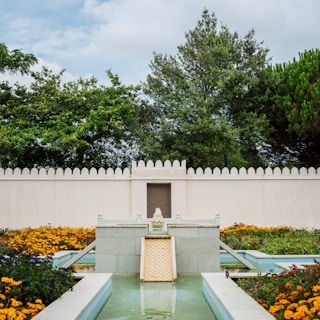 A serene backyard featuring a custom water fountain surrounded by flowers.