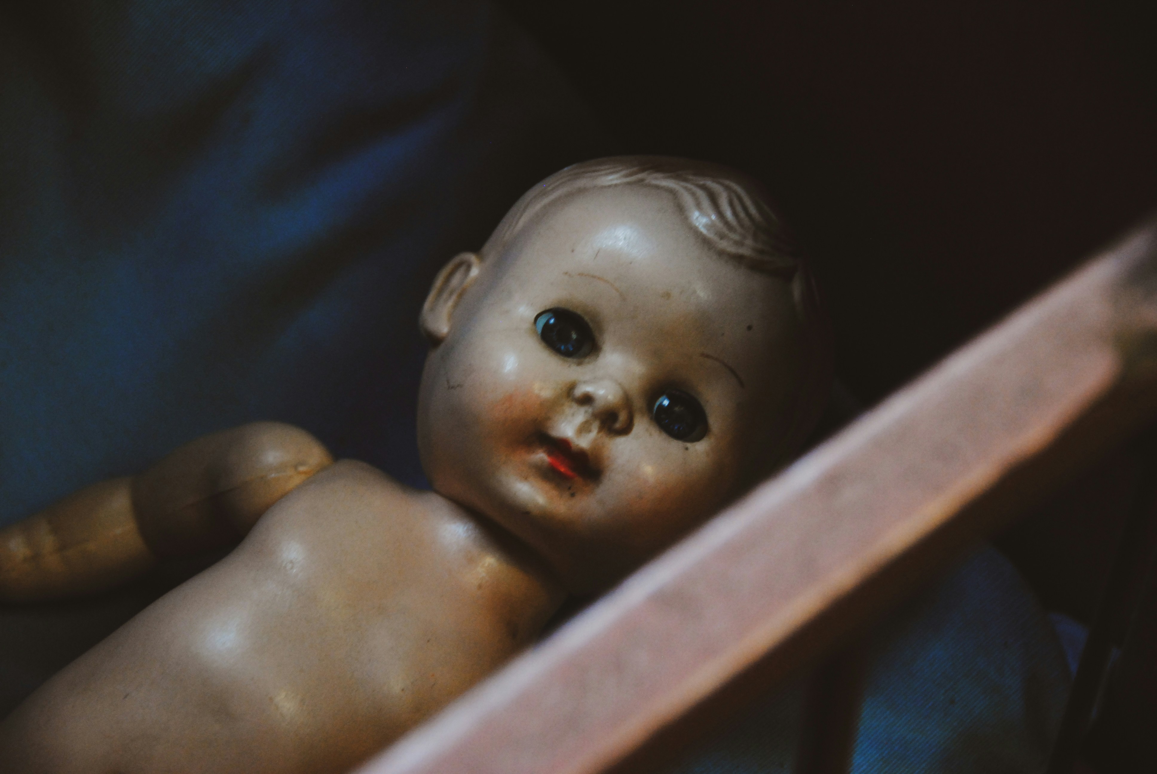 Naked porcelain doll in a drawer.