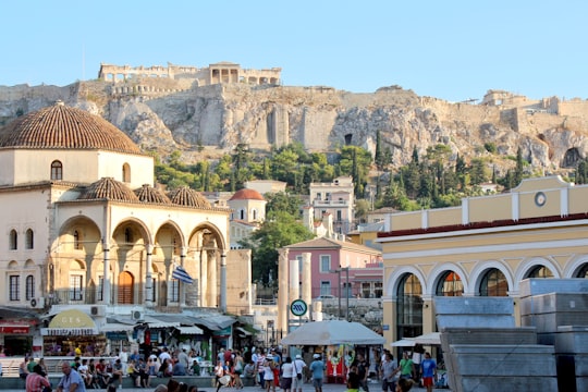 people walking on street near brown concrete building during daytime in Monastiraki Greece