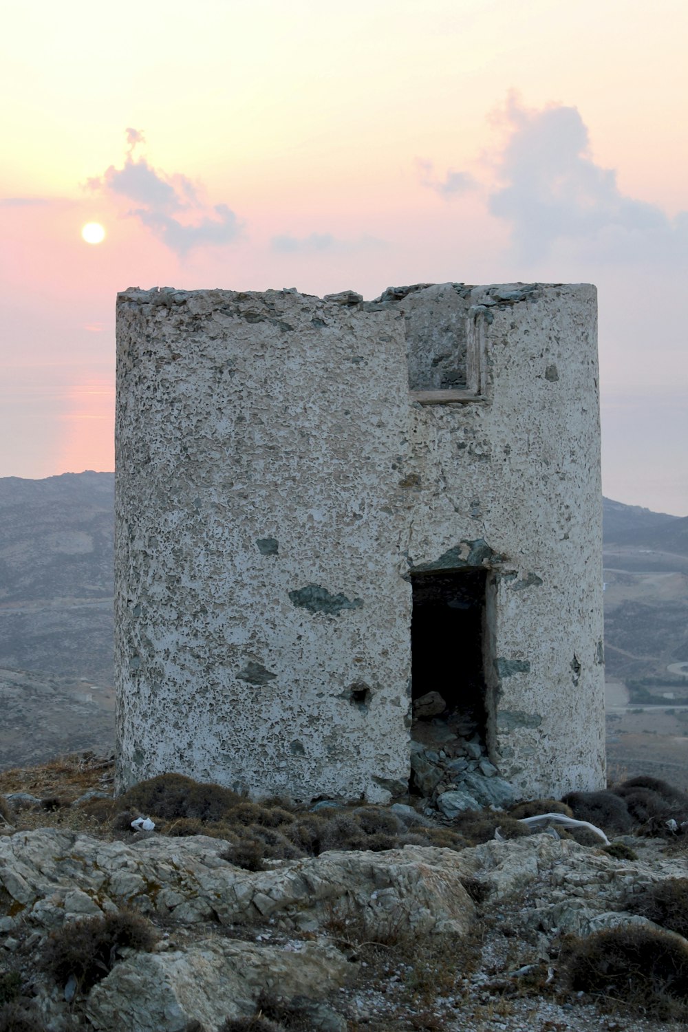 gray concrete building on rocky shore during daytime