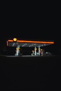 A Shell station illuminated at night.