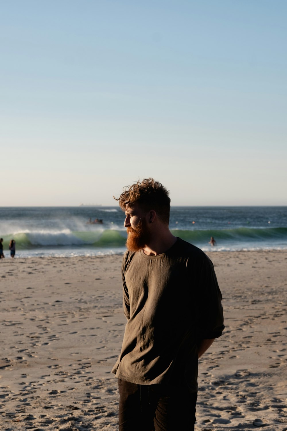 man in black crew neck t-shirt standing on beach during daytime