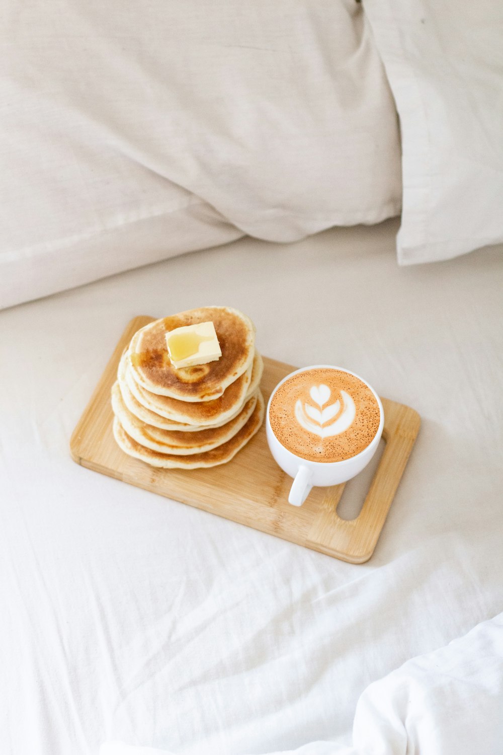 two brown and white doughnuts on brown wooden tray