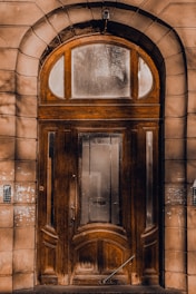 A large, sturdy door with a golden handle shining in natural light.