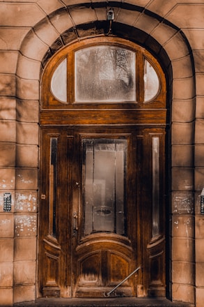 A large, sturdy door with a golden handle shining in natural light.