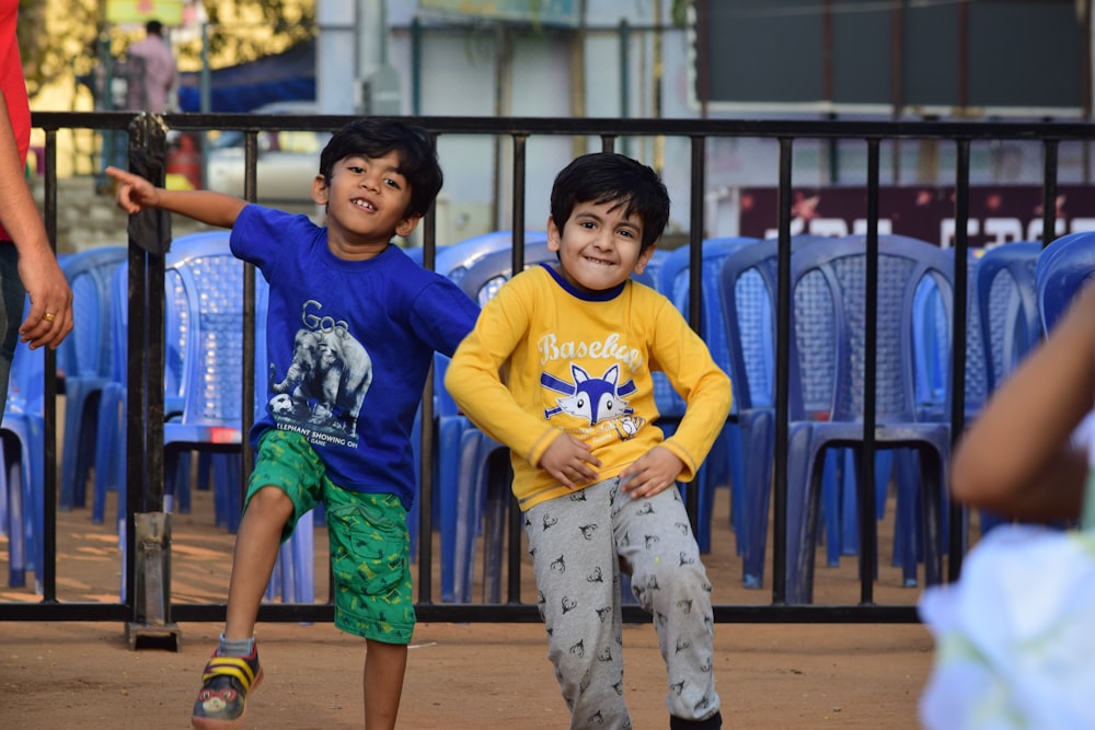 Garçon en T-shirt à col rond bleu et jaune debout à côté du garçon en col rond bleu