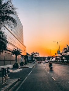 people walking on sidewalk near building during sunset
