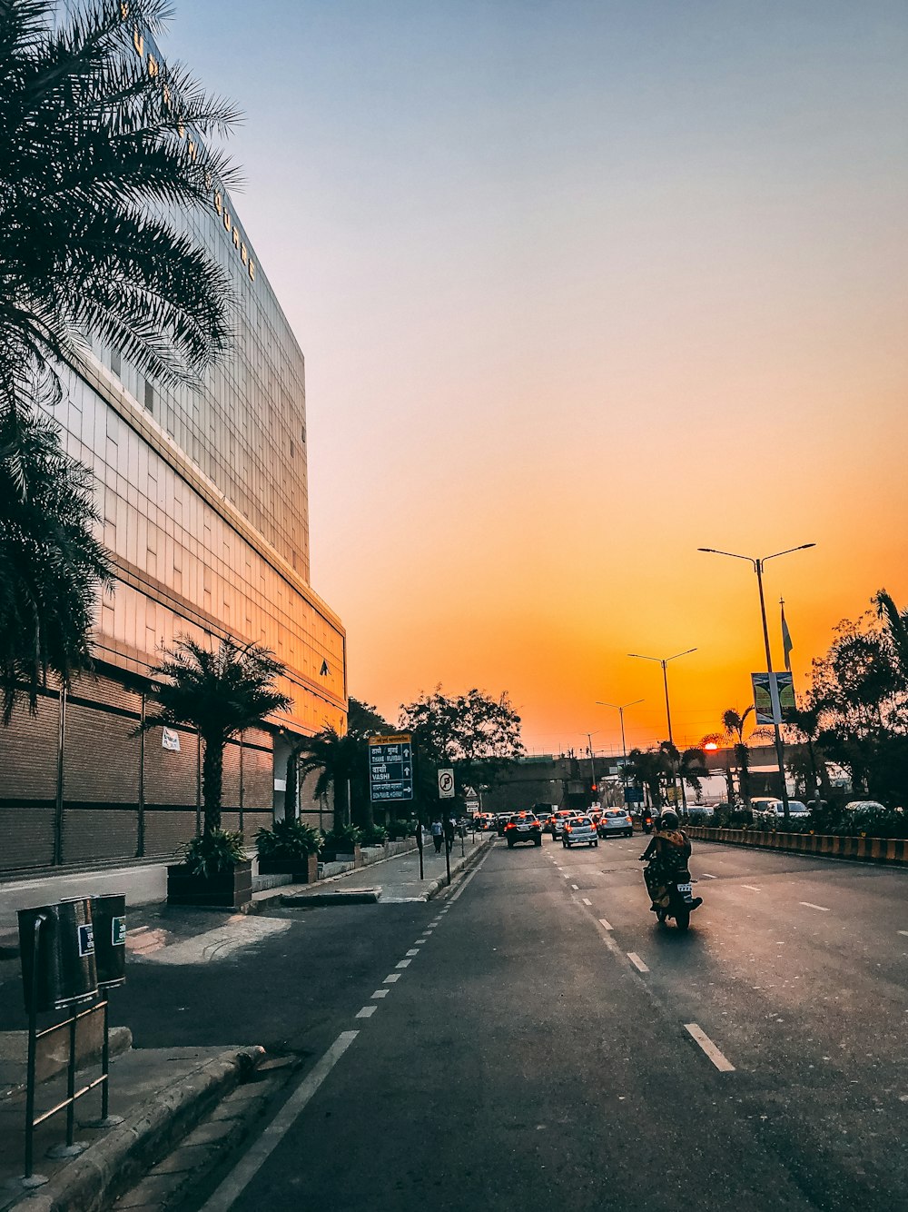 people walking on sidewalk near building during sunset