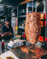 man in black button up shirt standing in front of food display