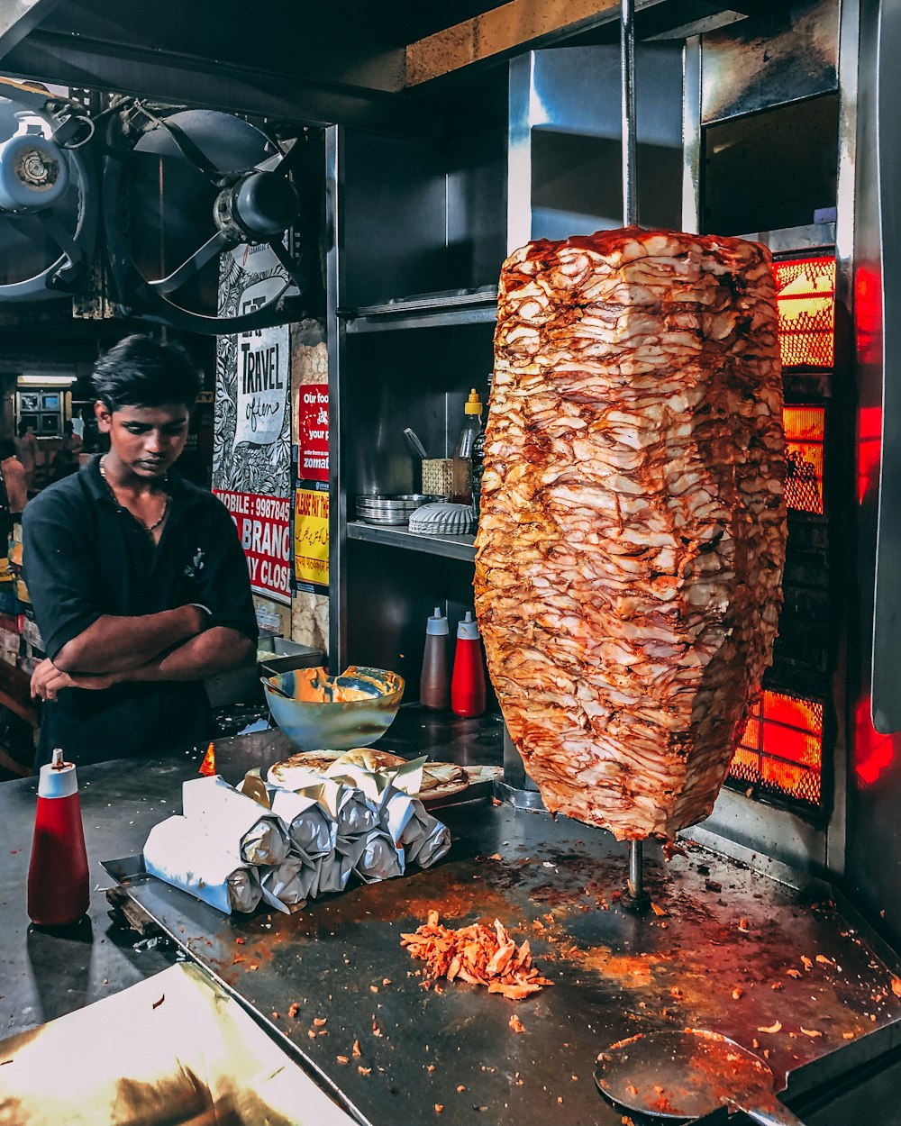 man in black button up shirt standing in front of food display