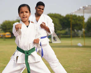 Older mestre guiding younger capoeiristas in graceful roda movements outdoors