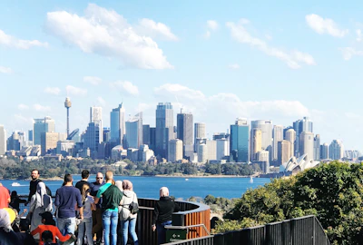 people standing on the edge of a building looking at the city during daytime
