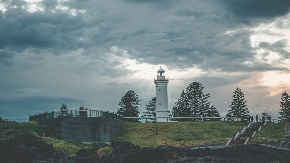 white lighthouse under cloudy sky during daytime