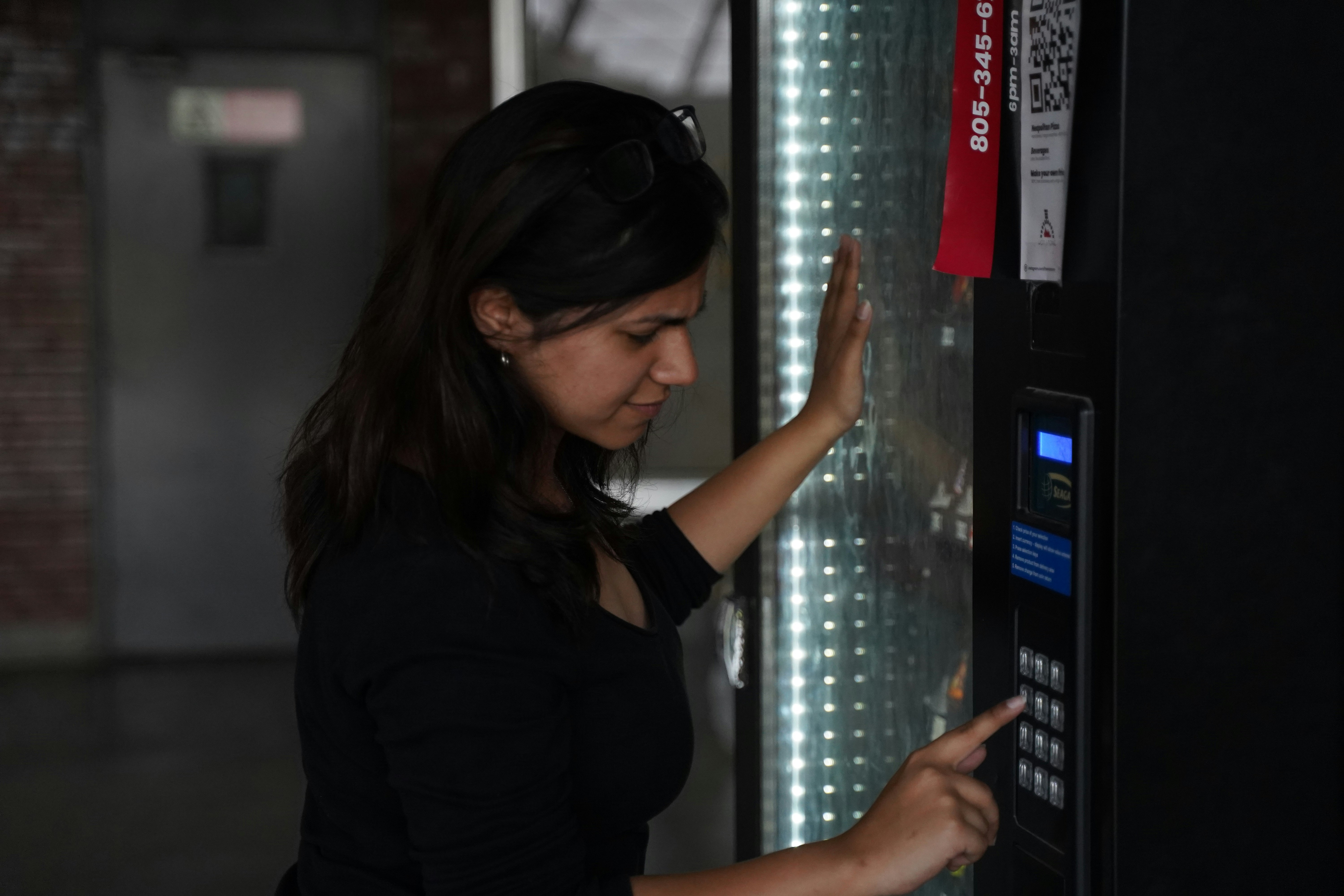 A girl using the vending machine. Theme: Impatience.