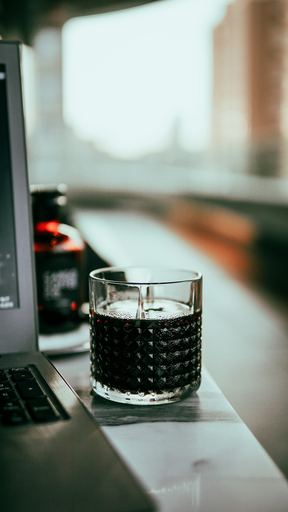 clear drinking glass on black laptop computer