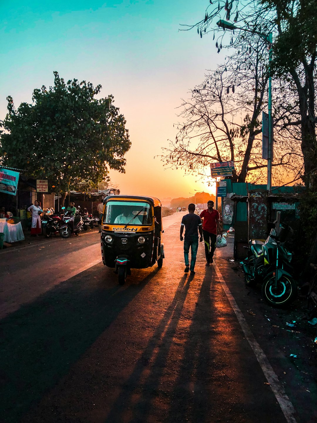 Sunset, A Rickshaw and two men walking. 