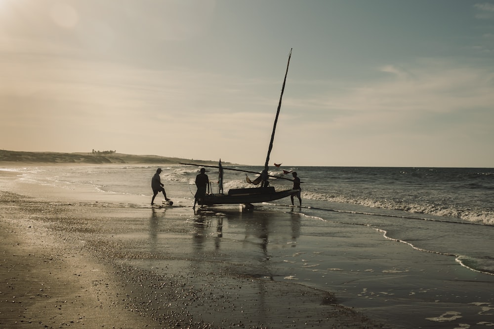 man in black shirt and black shorts sitting on boat on beach during daytime