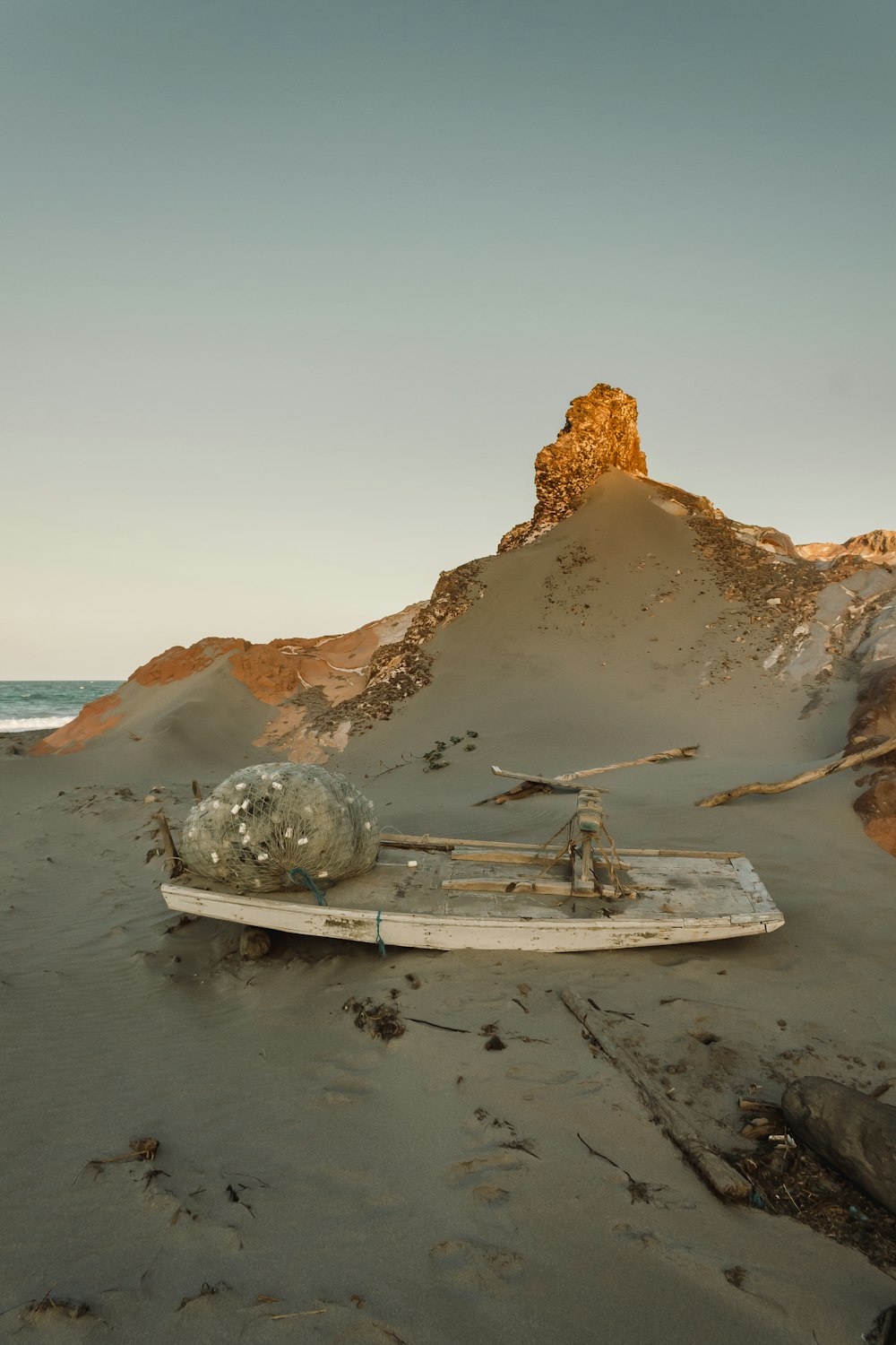 brown wooden boat on seashore near brown rock formation during daytime