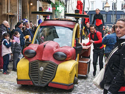 A lively road show event with branded vehicles and enthusiastic crowds.