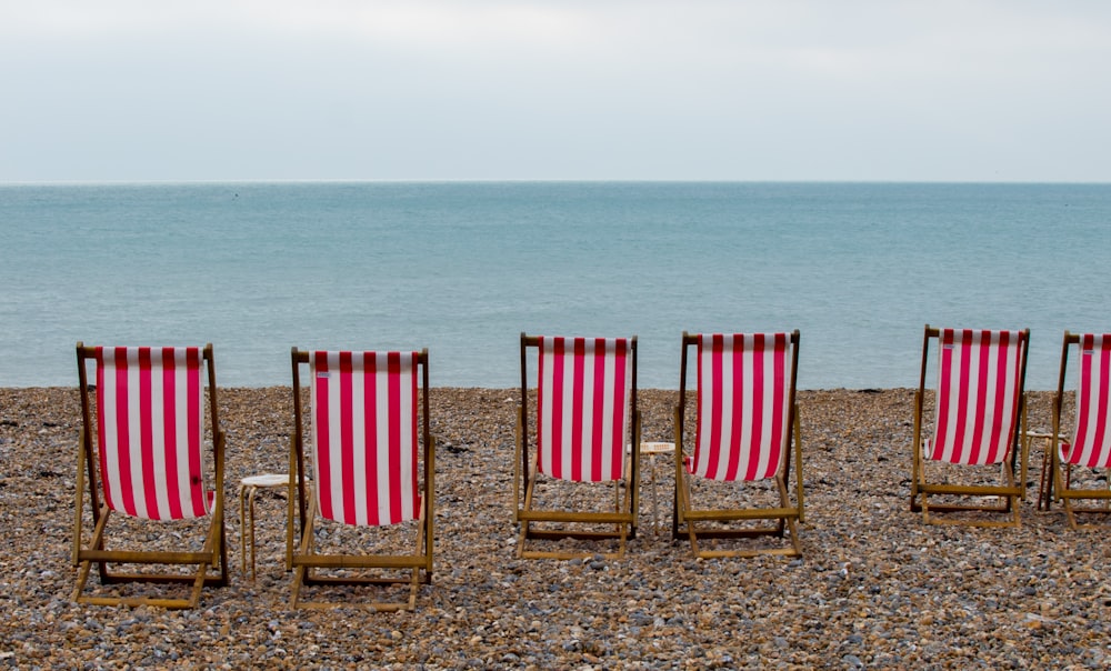 red and white striped folding chair on beach during daytime
