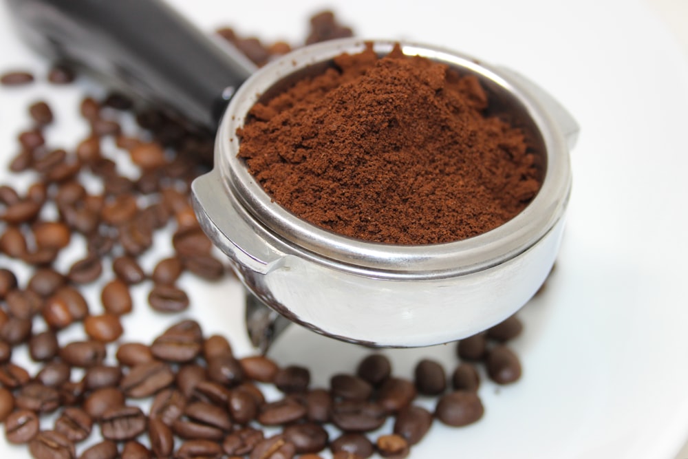 coffee beans on white ceramic mug