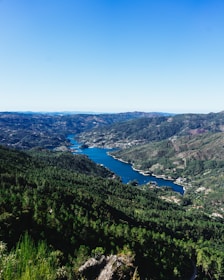 Close-up aerial view of a river cutting through the Serra da Mantiqueira landscape under clear blue skies.