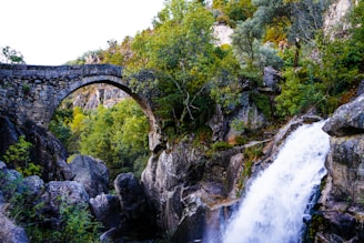 waterfalls under bridge during daytime