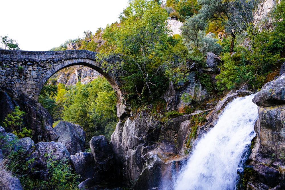 waterfalls under bridge during daytime