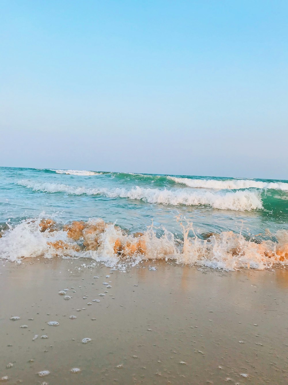 ondas do mar batendo em terra durante o dia