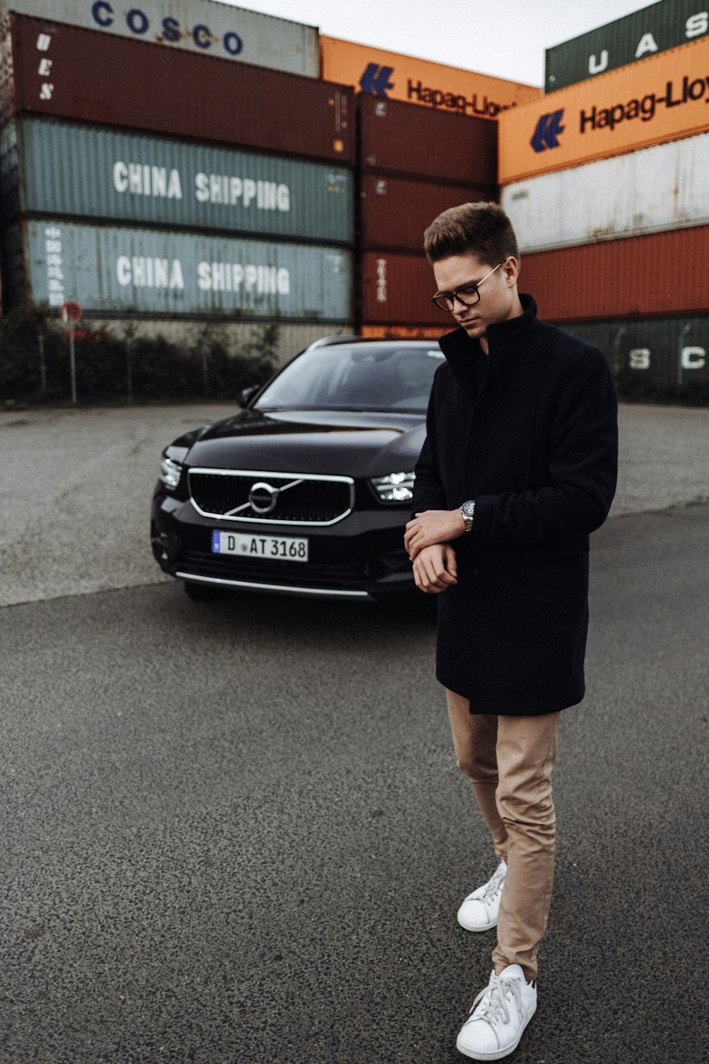 man in black blazer standing beside black mercedes benz car